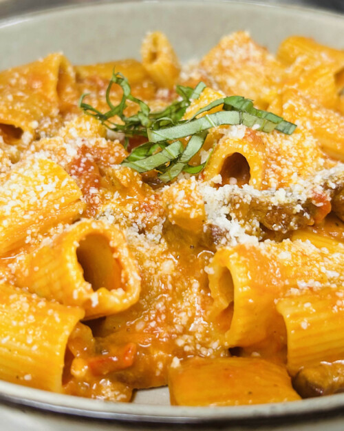 happy-hour pasta topped with sauce and parmesan cheese
